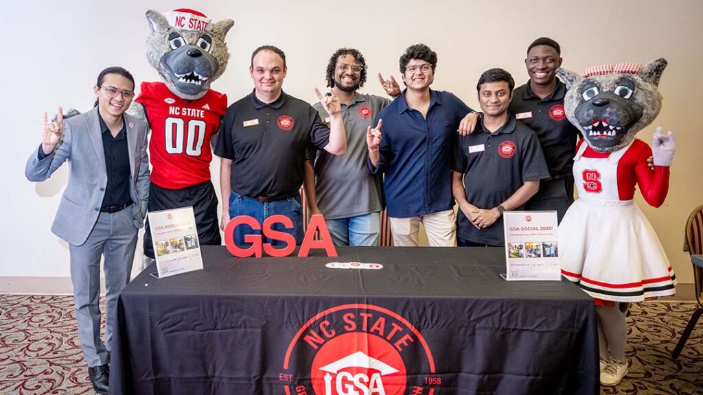 Arjun with members of the NC State Graduate Student Association and the university mascots at a GSA table